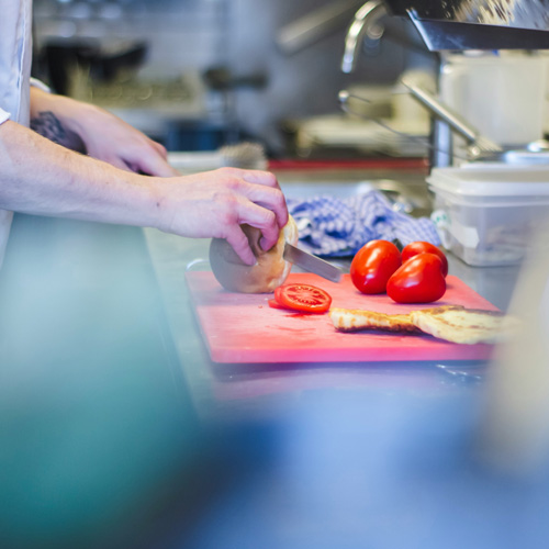 une personne est en train de couper des tomates