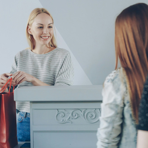 Deux personnes dans un magasin en train de terminer une vente à la caisse
