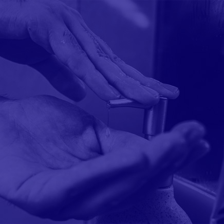 Mains pressant d'une bouteille de savon